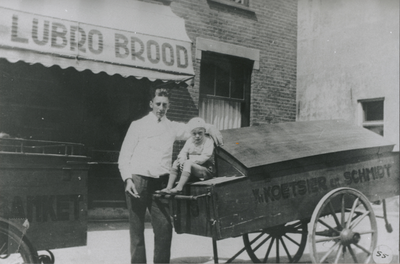 875157 Portret van dhr. Roks met zijn zoontje Cor bij twee broodkarren voor het filiaal van de Lubro-bakkerij ...